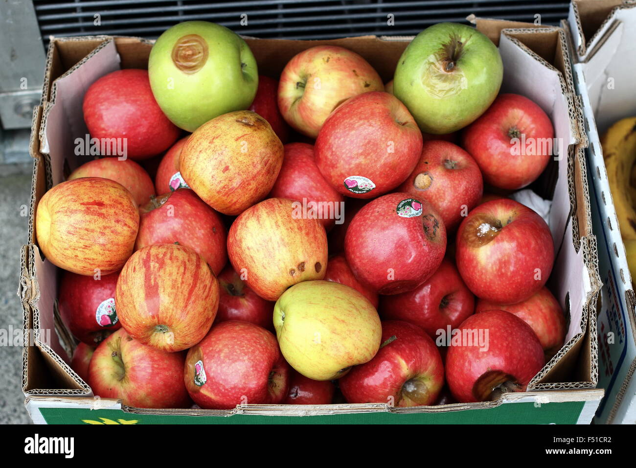 Mele marce in una scatola di cartone al mercato Foto Stock