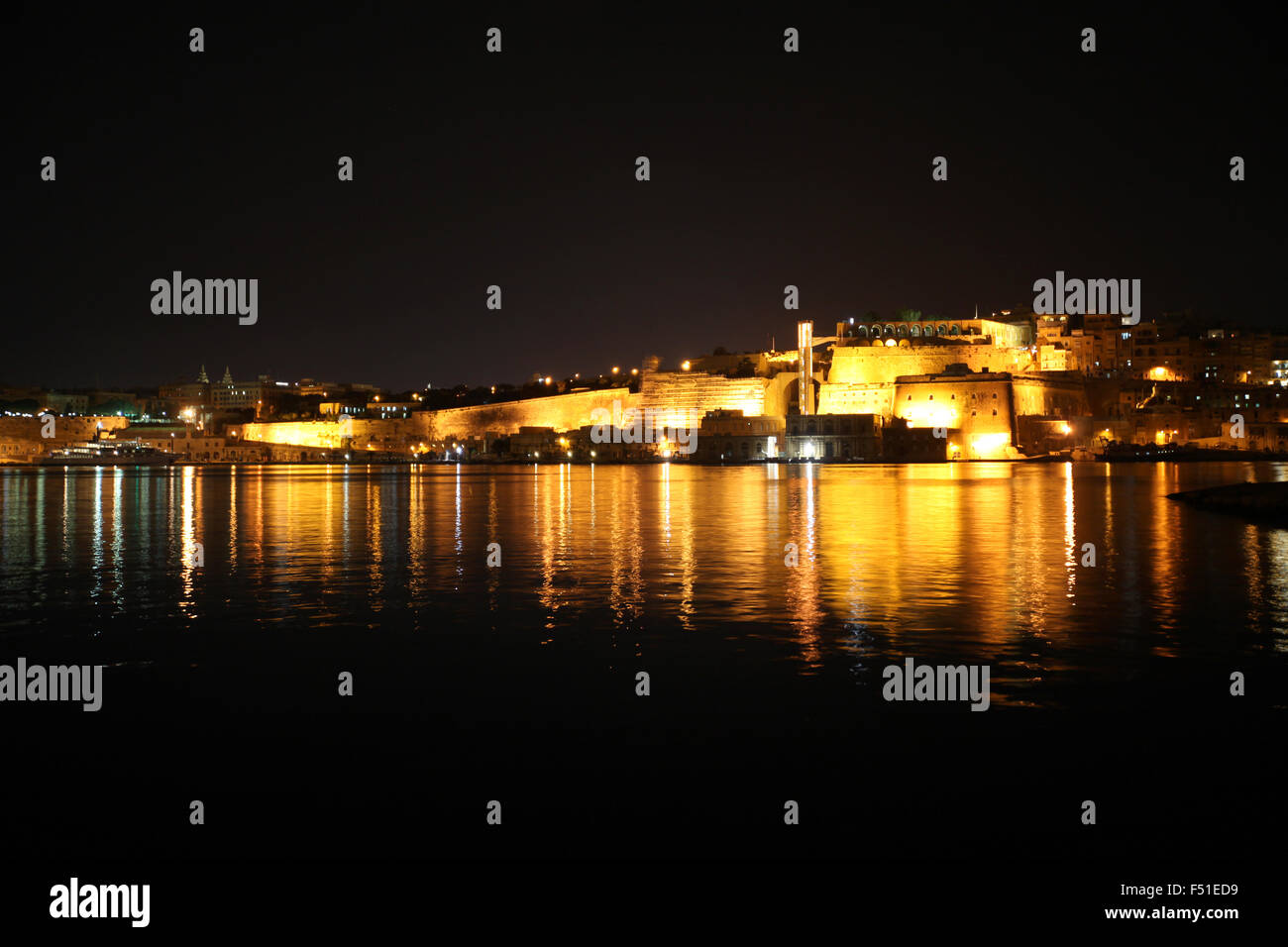 Notte in Grand Harbour cercando di fronte a La Valletta e Barakka Gardens dal Forte Sant'Angelo Foto Stock