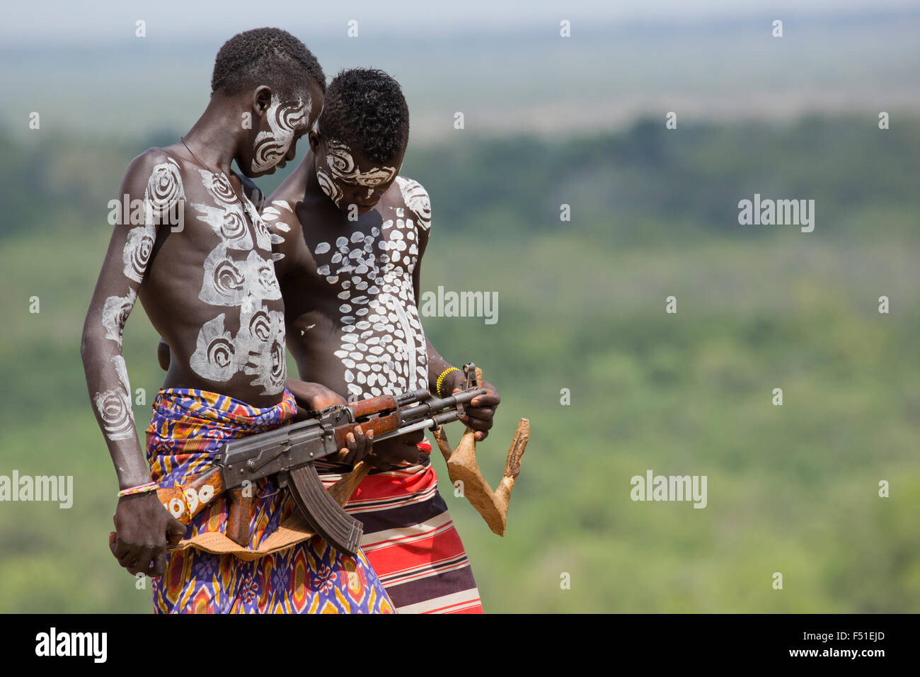 Giovane maschio Karo tribù ragazzi con AK-47 fucile . Valle dell'Omo, Etiopia Foto Stock
