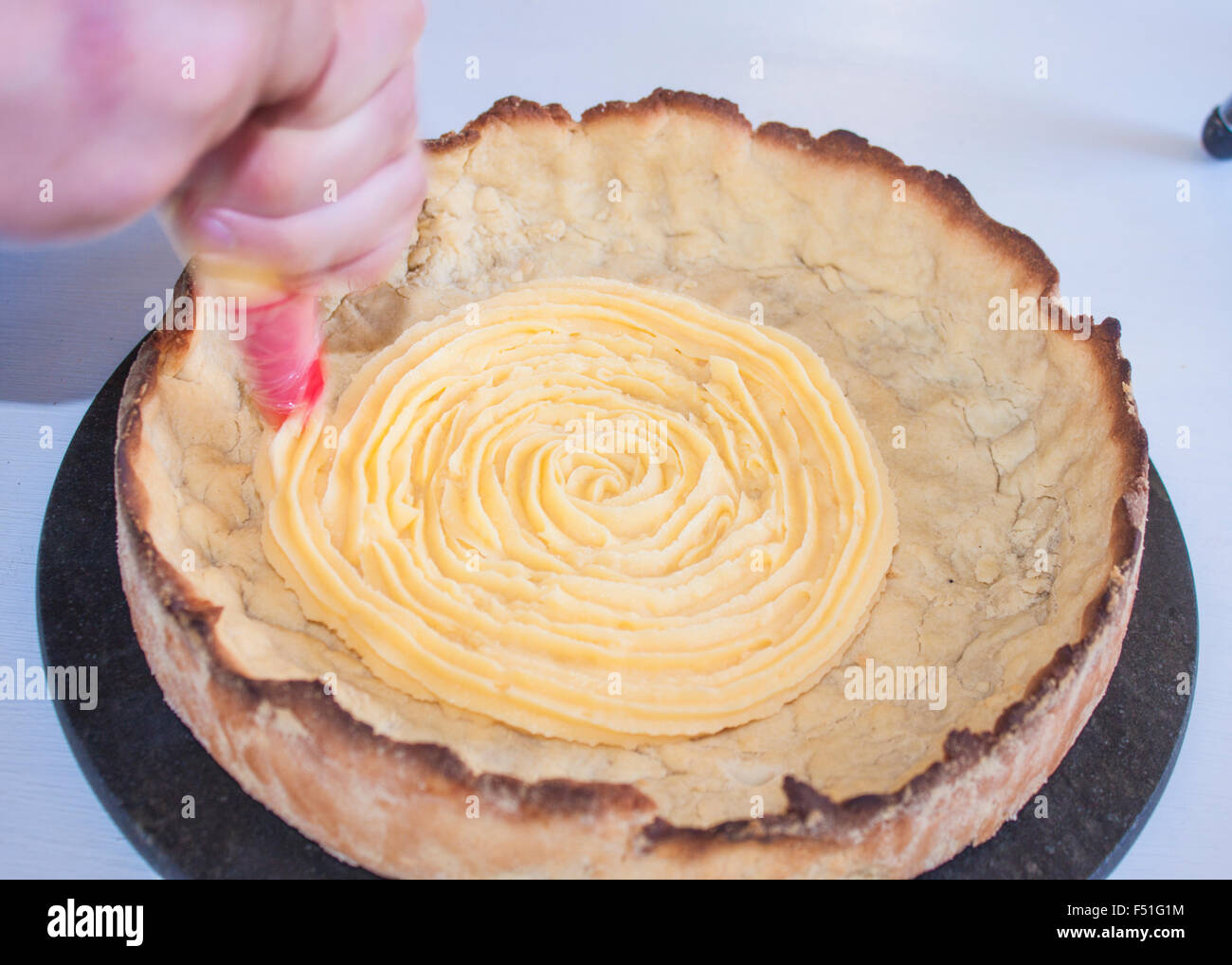 La spremitura di cagliata di limone, su un fondo di torta Foto Stock