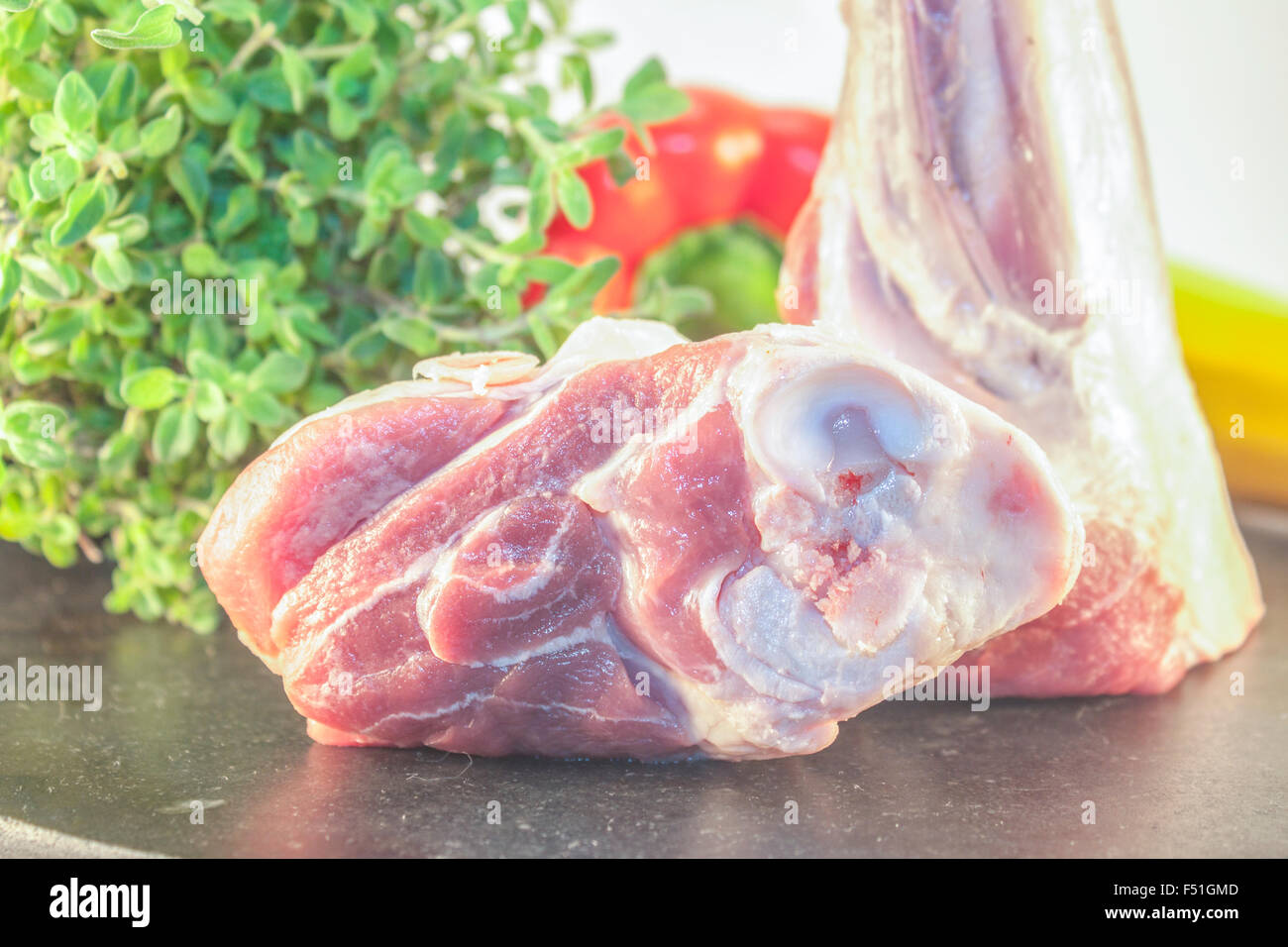 Due codoli di agnello, nei pressi di pepe rosso, erbe aromatiche e zucchine giallo Foto Stock