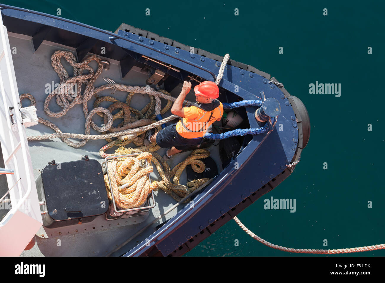 Ajaccio, Francia - 30 Giugno 2015: le operazioni di ormeggio, l uomo al lavoro con funi su un arco di piccolo rimorchiatore Foto Stock