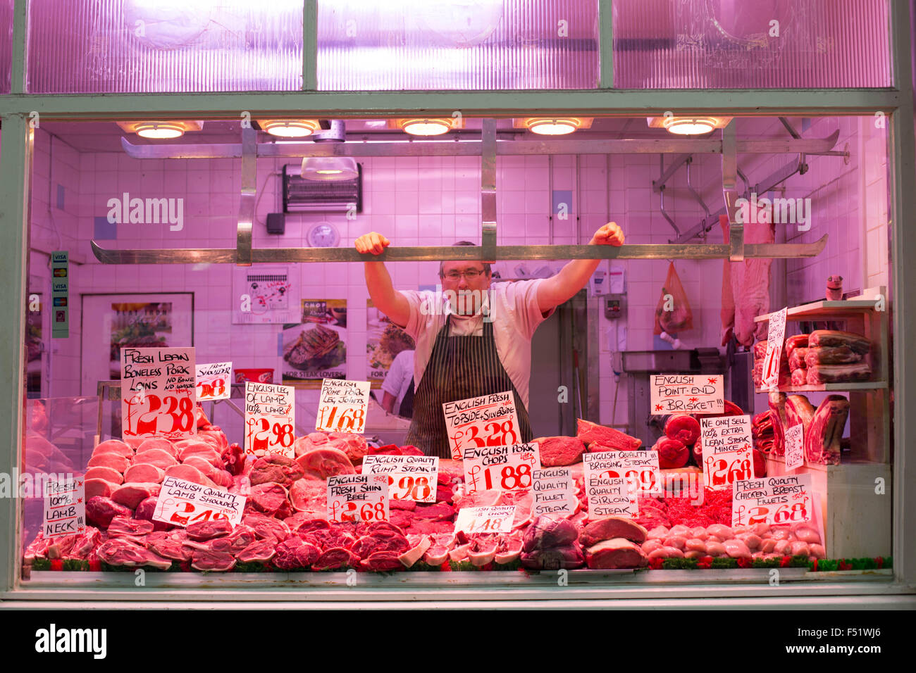 Un macellaio al suo stallo in Leeds Kirkgate Mercato nel West Yorkshire, Regno Unito. È il più grande mercato coperto in Europa. Foto Stock