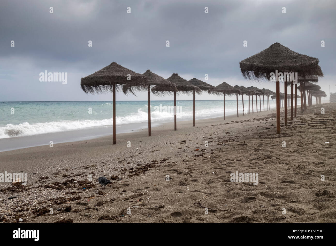 Spiaggia mediterranea con ombrelloni durante le giornate di cattivo tempo, Spagna. Foto Stock