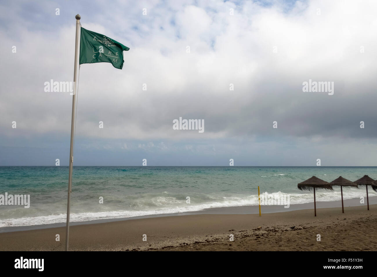Bandiera verde mediterraneo, spiaggia con ombrelloni durante le giornate di cattivo tempo, Spagna. Foto Stock