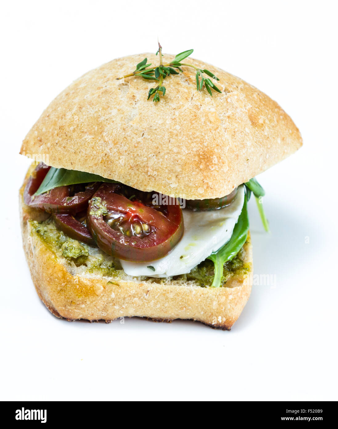 Mozzarella Fresca e sandwich di pomodoro con basilico fresco su uno sfondo bianco Foto Stock