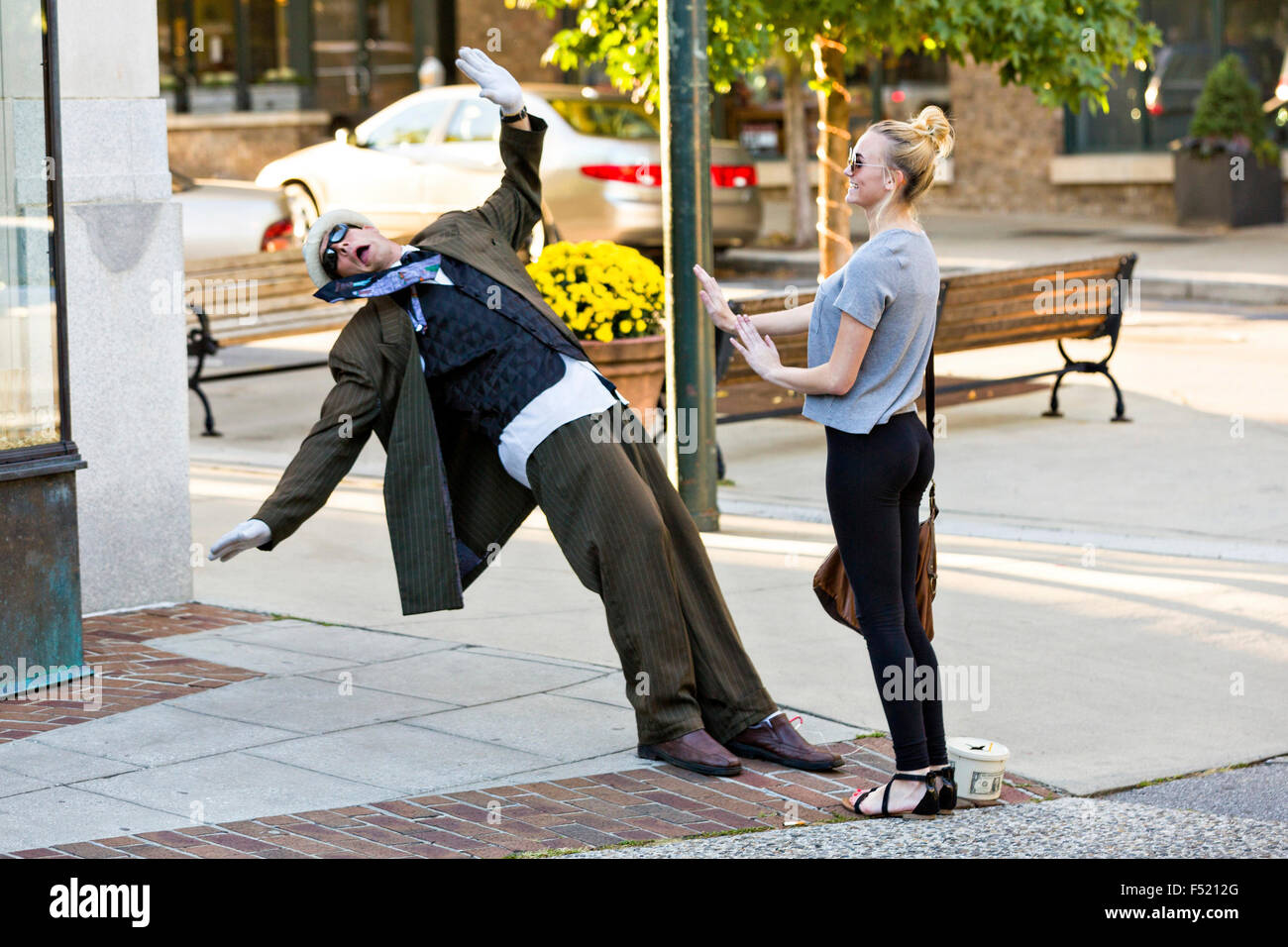 Un esecutore di strada sembra cadere indietro per un turista in Asheville, North Carolina. Foto Stock