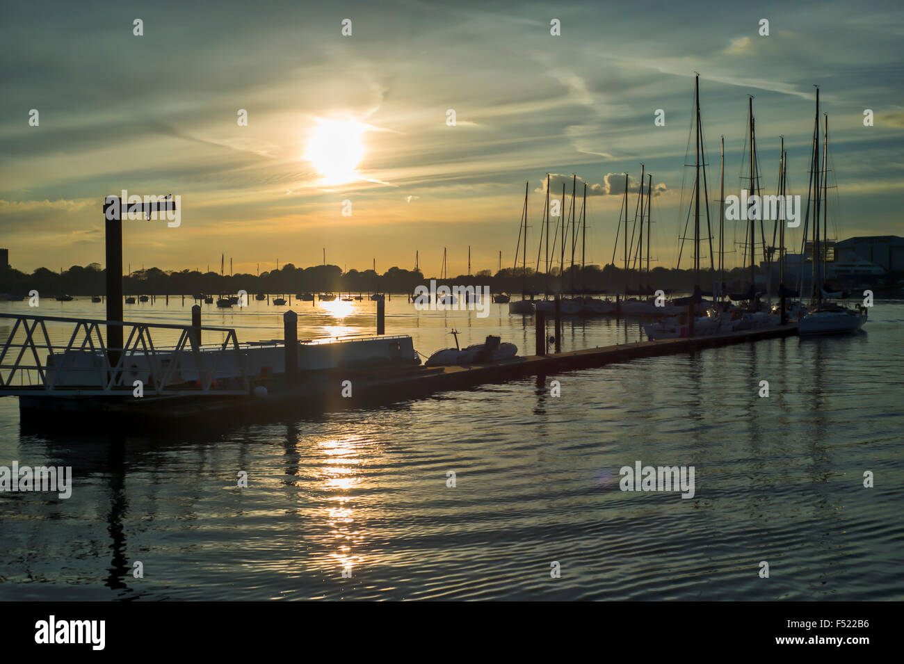 Yachts sull'esterno pontone di attesa a Port Solent Marina al tramonto Foto Stock