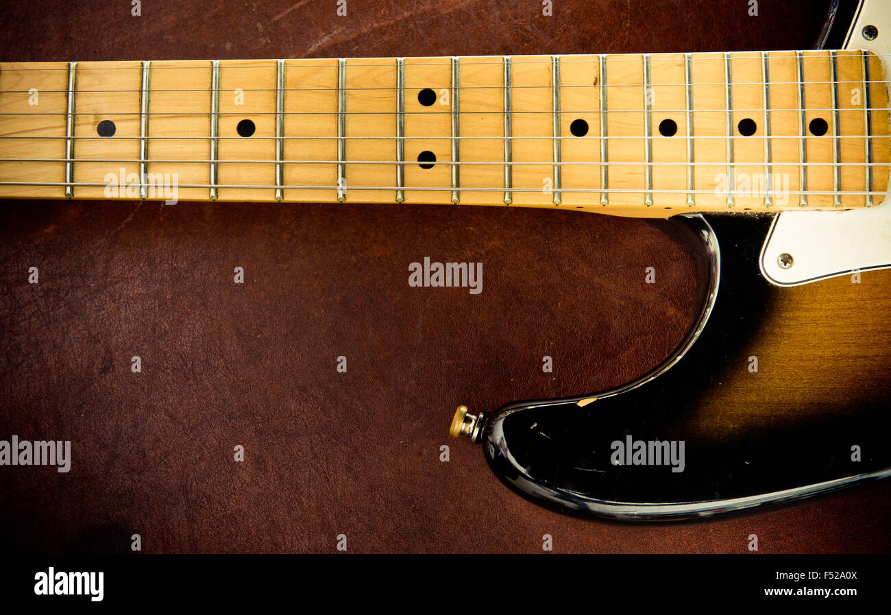 Chitarra elettrica della parte di corpo con graffi e collo dettaglio su sfondo di legno, look vintage Foto Stock