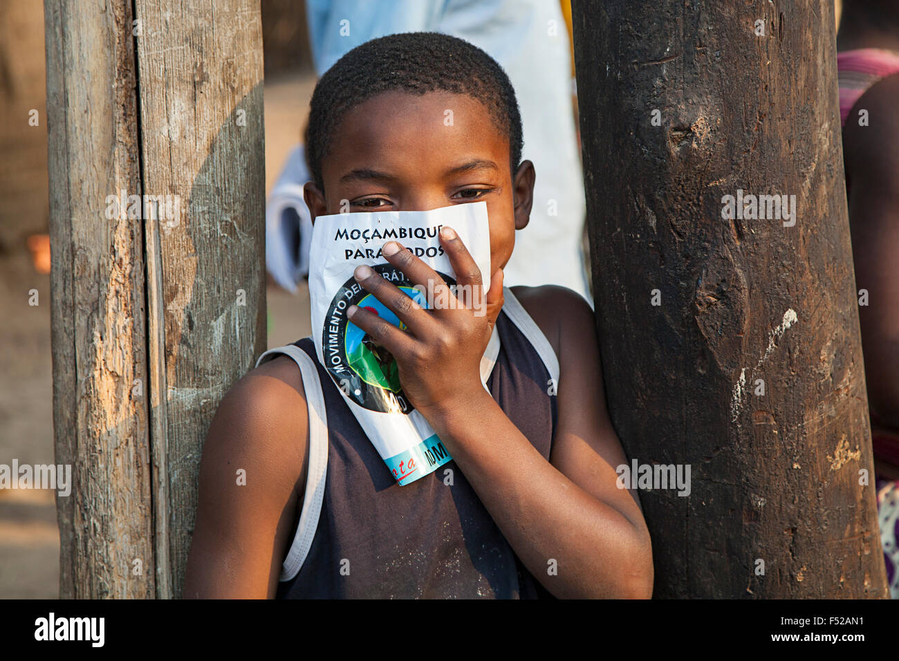 Piccolo capretto dal nord del Mozambico tenendo un manifesto elettorale dicendo "Mozambico per tutti" Foto Stock