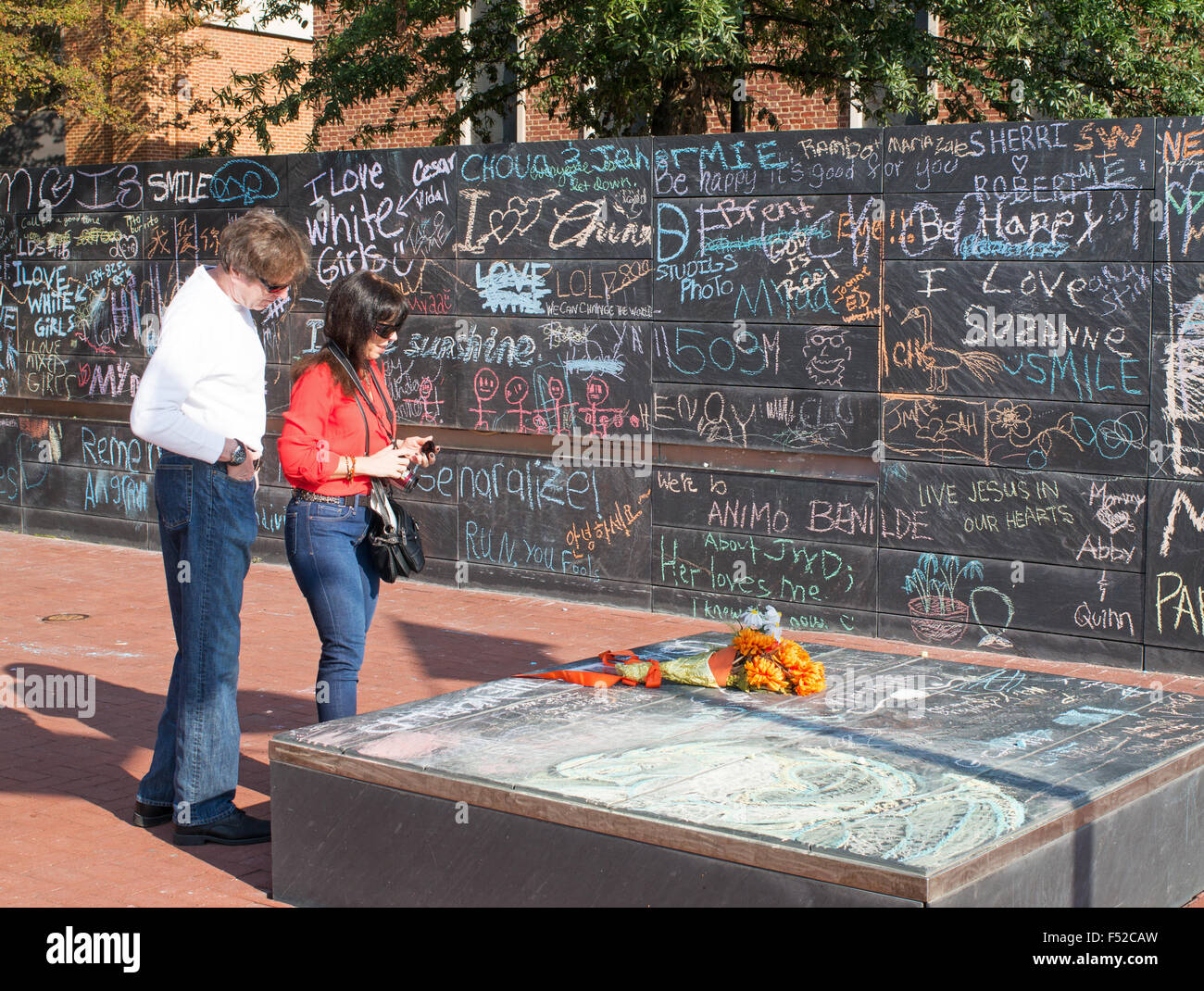 Giovane guardando omaggio floreale alla assassinato studentessa a Charlottesville Comunità Chalkboard podio, Virginia, Stati Uniti d'America Foto Stock