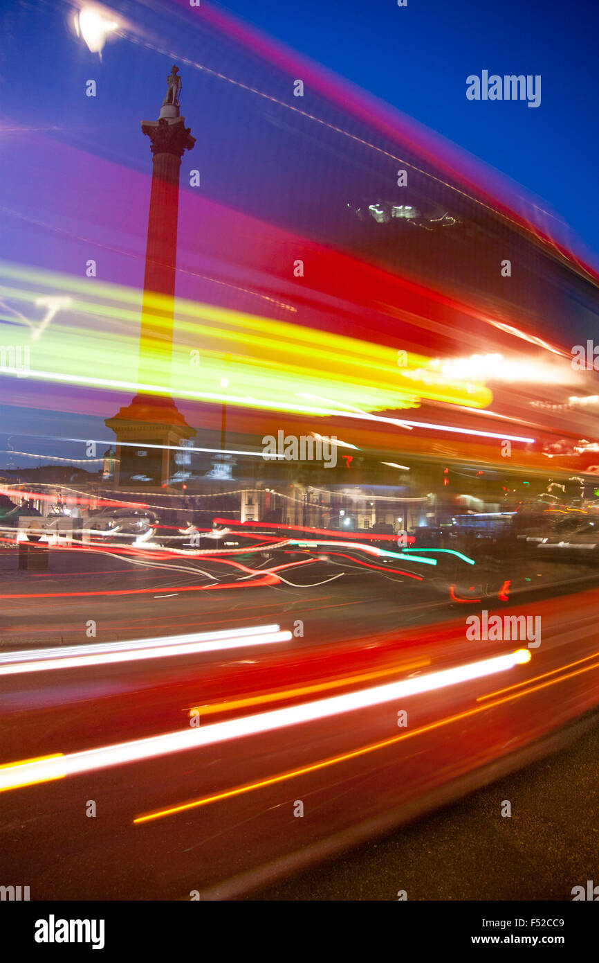 Trafalgar Square red London bus di notte con luci motion blur Nelson la colonna del background in Londra England Regno Unito Foto Stock