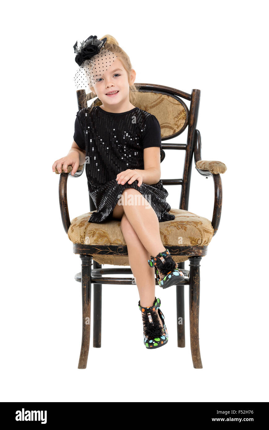 Bambina seduto nella sedia antica, su sfondo bianco Foto Stock