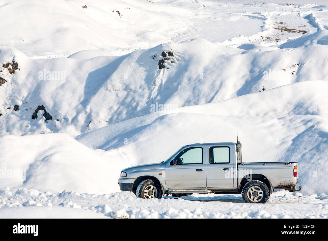 Auto In uno scenario invernale con i contrassegni sulla strada suggerendo Guida Fuoristrada Foto Stock