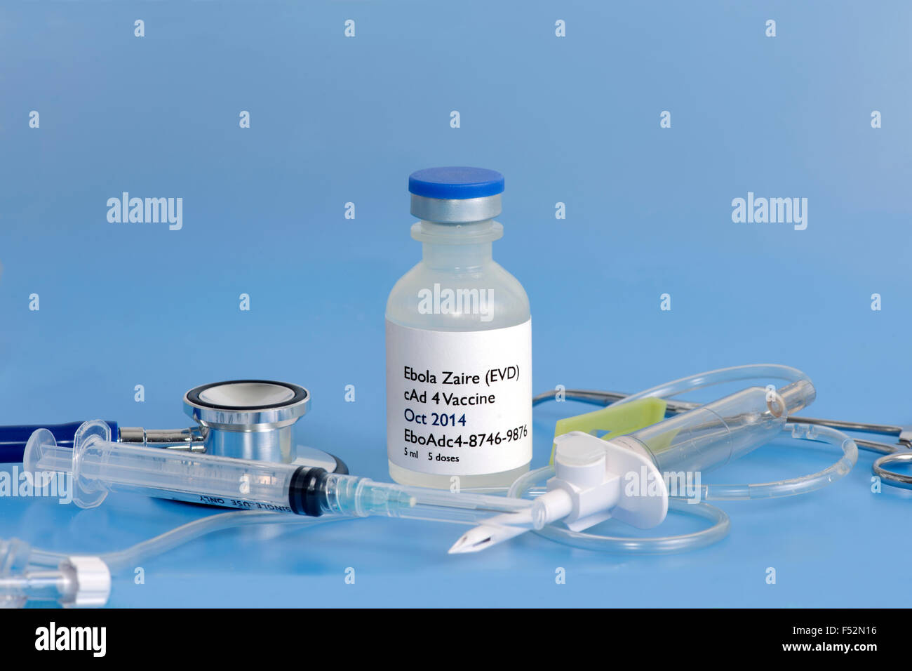 Il virus di Ebola vaccino con siringa ipodermica, uno stetoscopio e IV camera di gocciolamento su sfondo blu. Foto Stock