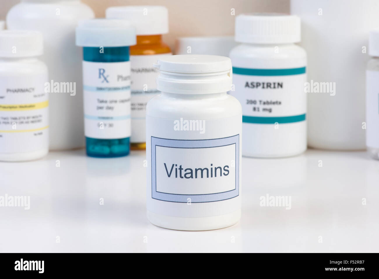 Vitamina bottiglia sul bancone con bottiglie di prescrizione in background. Foto Stock