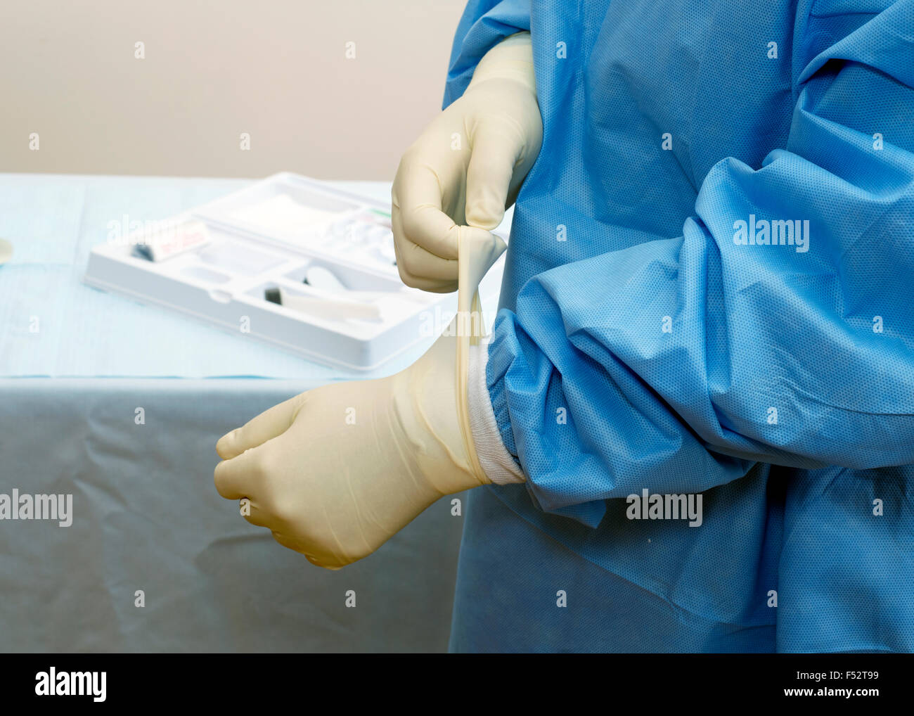 Chirurgo mettendo su guanti sterili prima dell'operazione. Foto Stock