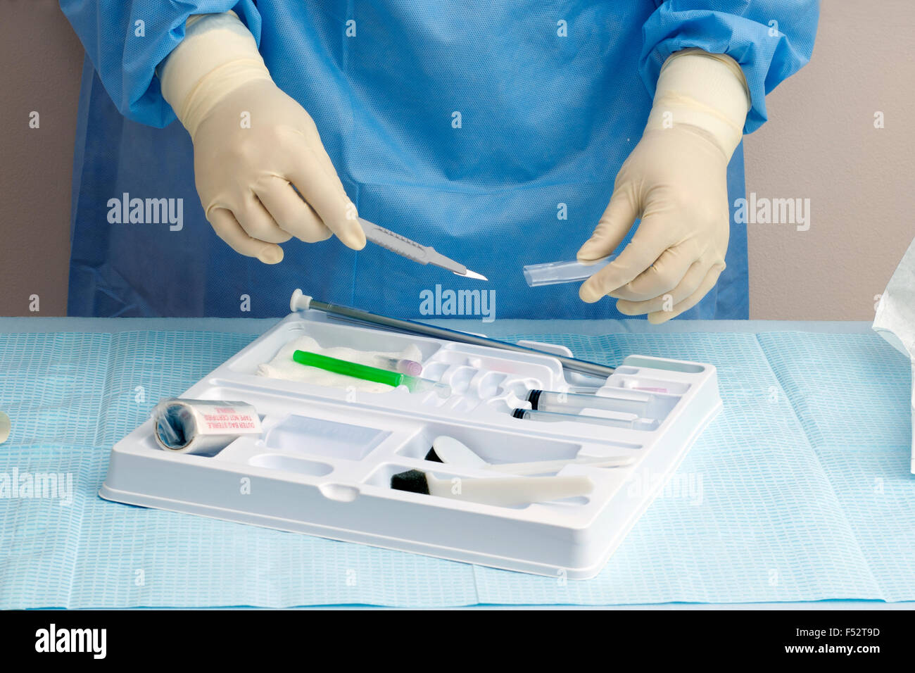 L'infermiera si prepara un bisturi per l'utilizzo con un catetere di trequarti kit. Foto Stock