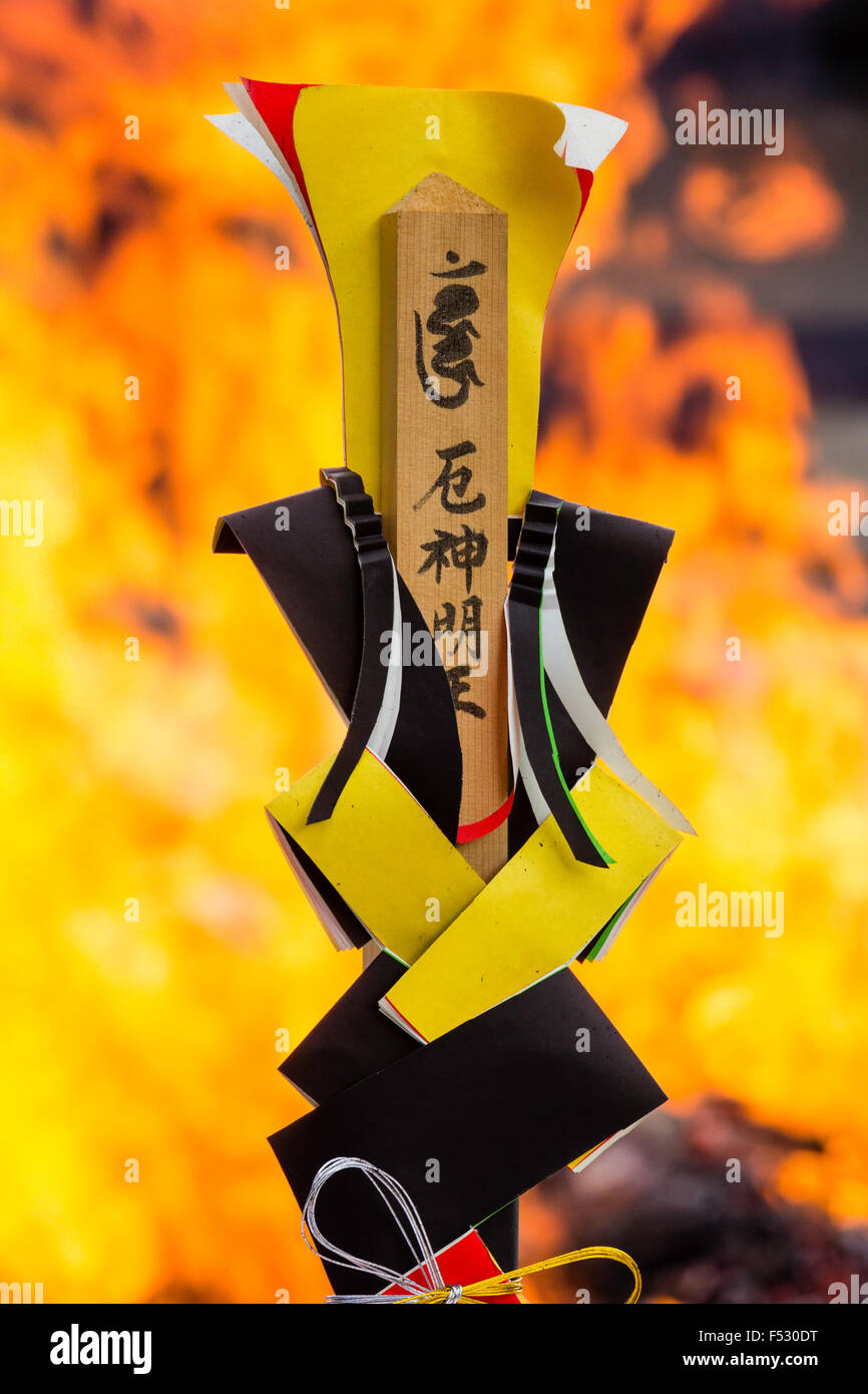 Giappone, Nishinomiya, Mondo Yakujin Tempio. Lo Shintoismo simbolo in posizione eretta con le fiamme in background. Deep focus, ma le fiamme fuori fuoco. Foto Stock
