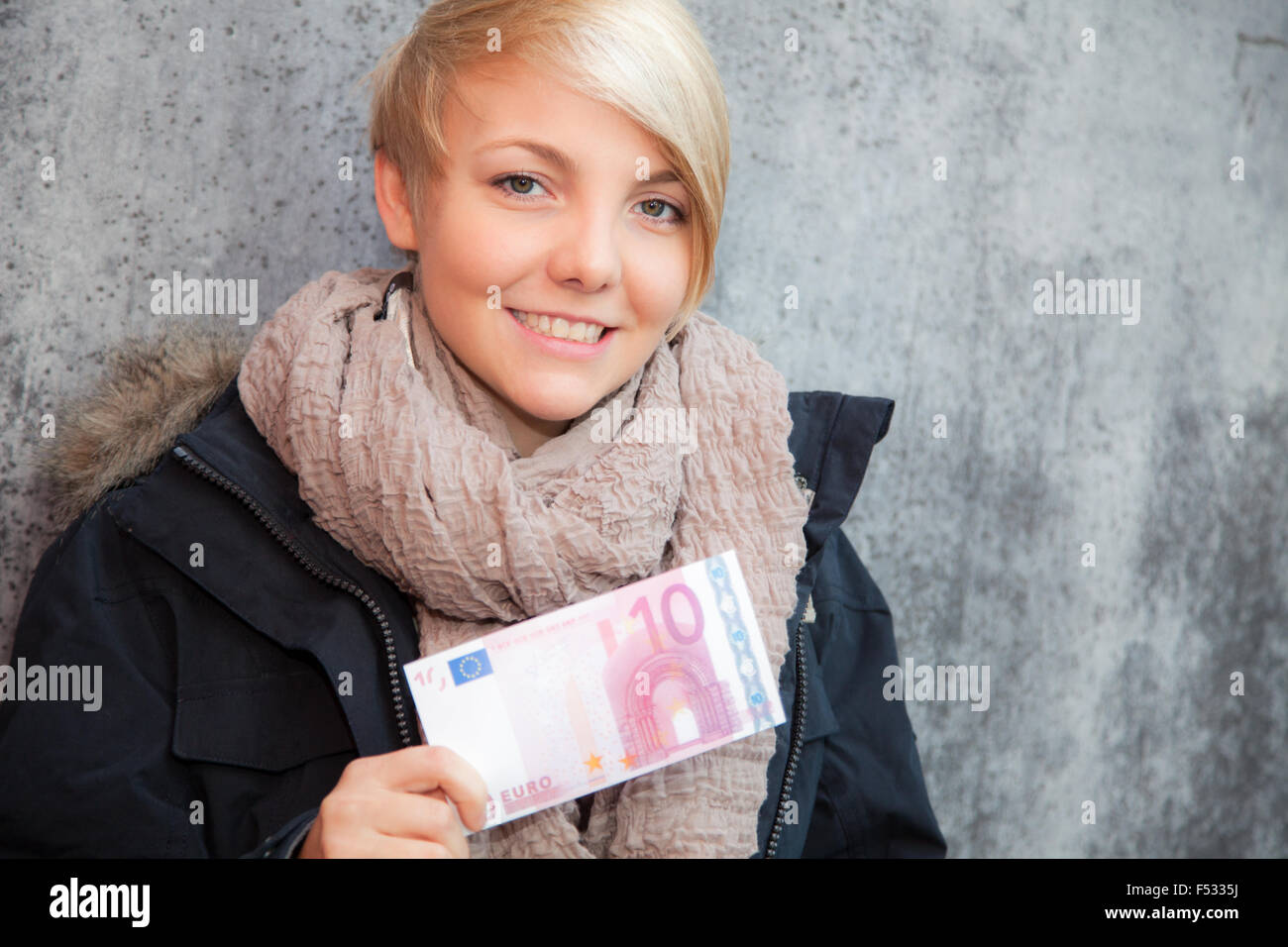 Attraente giovane donna azienda dieci euro nota Foto Stock