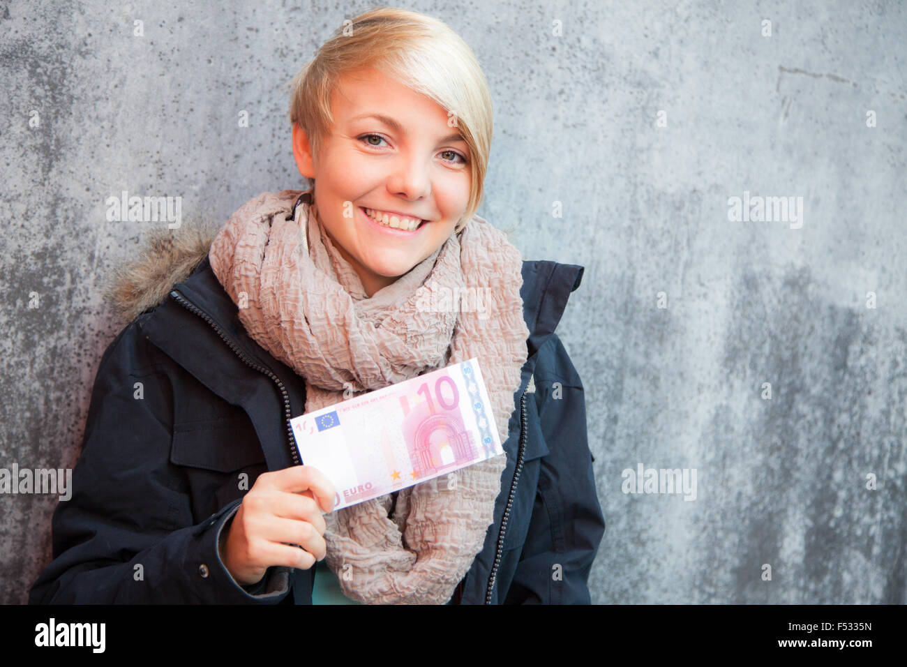 Attraente giovane donna azienda dieci euro nota Foto Stock