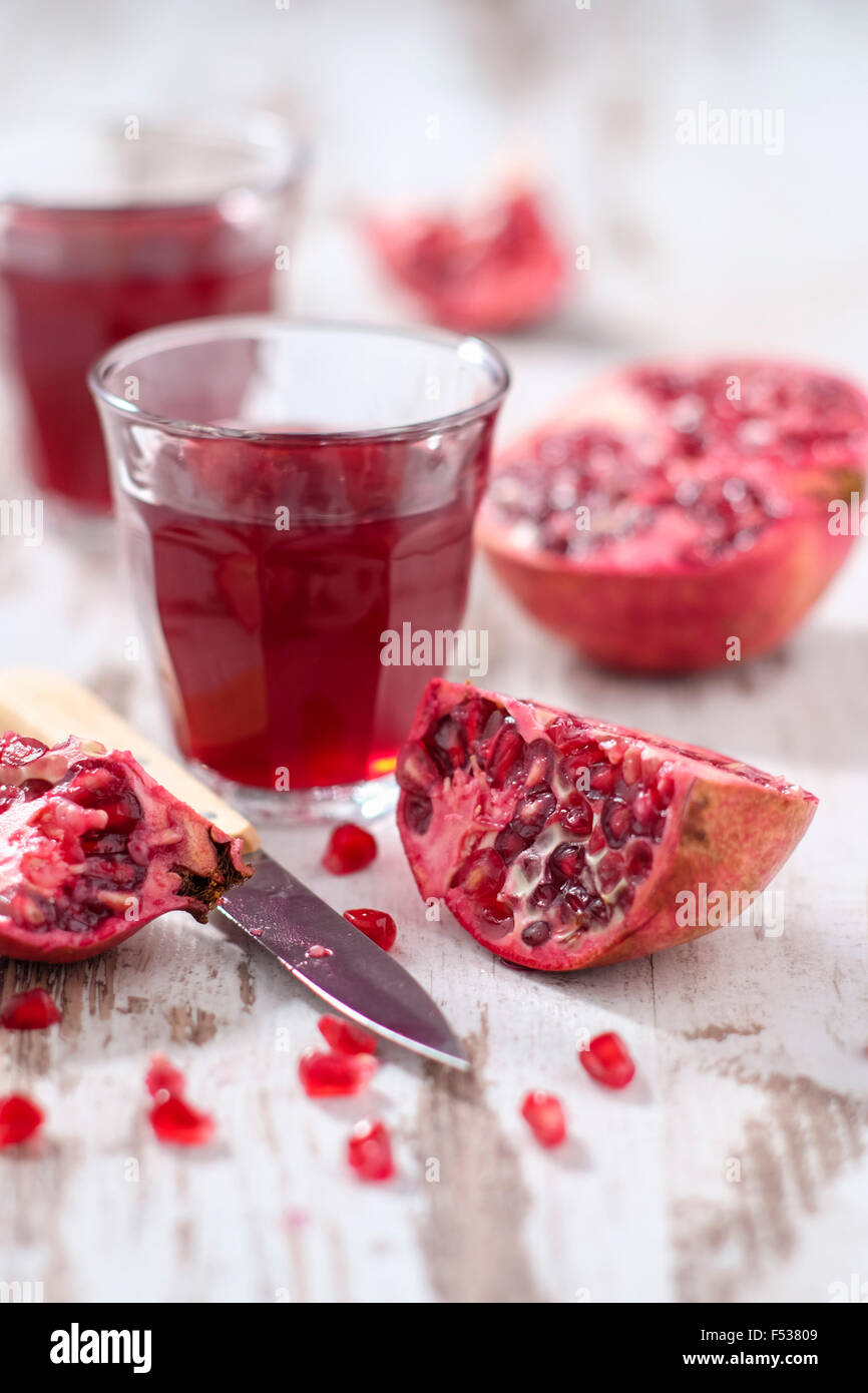 Fette di melograni, anime e vetro con succo di melograno Foto Stock