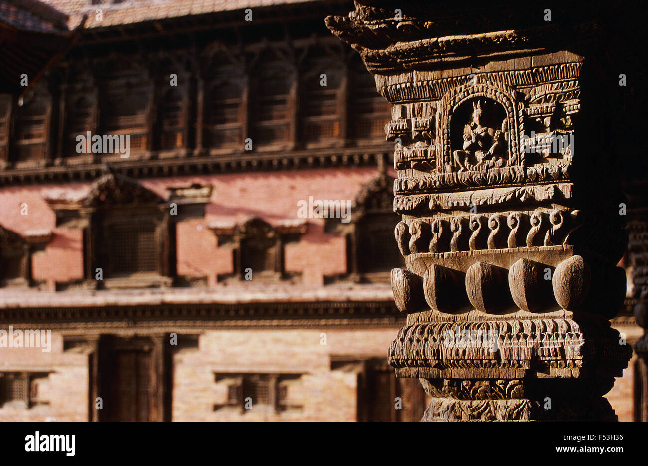 Montanti di legno che rappresenta il dio indù Shiva. In background, l'ex Palazzo Reale a Patan Nepal () Foto Stock