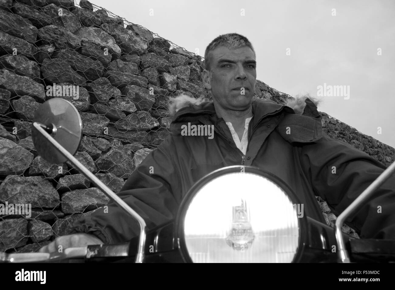 Mod maschio indossa Parka su Vespa Scooterwith faro sul davanti del muro di pietra (immagine di credito© Jack Ludlam) Foto Stock