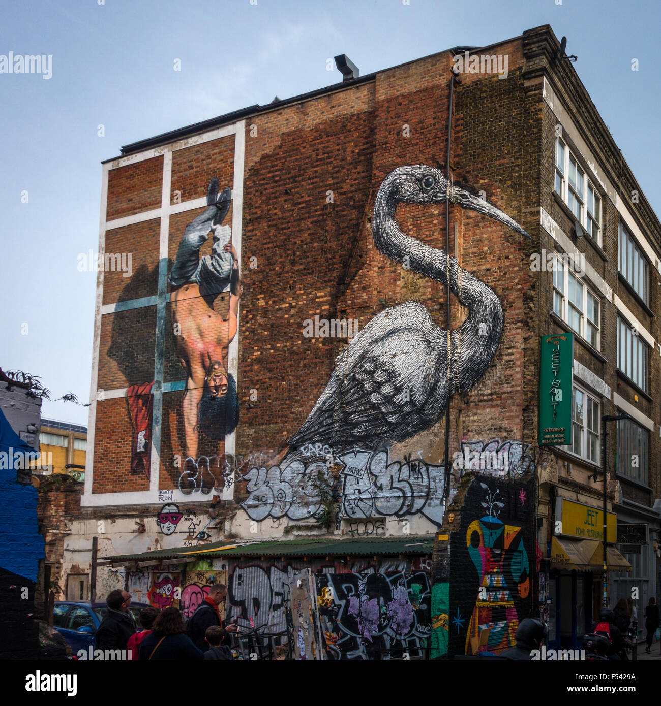 I turisti alla ricerca di graffiti su Hanbury Street, Off Brick Lane nell'East End di Londra. Foto Stock