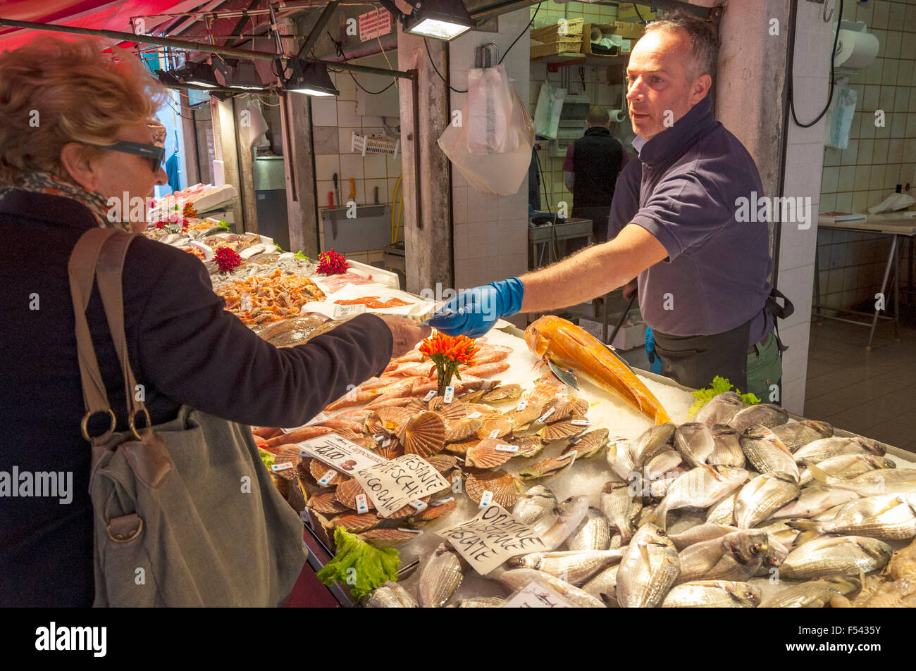 Donna shopping per il pesce in Pescheria Mercato del Pesce del Mercato di Rialto, Venezia, Italia Foto Stock