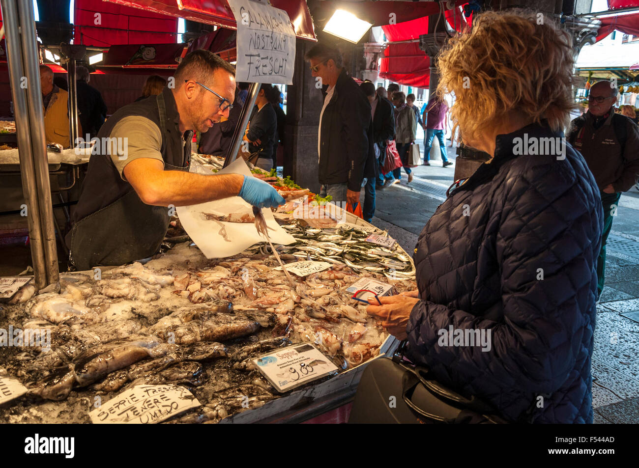 Donna shopping per i calamari alla Pescheria Mercato del Pesce del Mercato di Rialto, Venezia, Italia Foto Stock