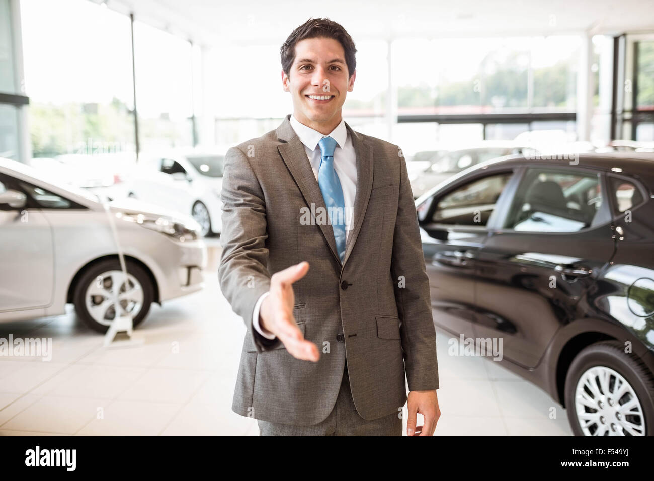 Sorridente venditore pronto a scuotere la mano Foto Stock