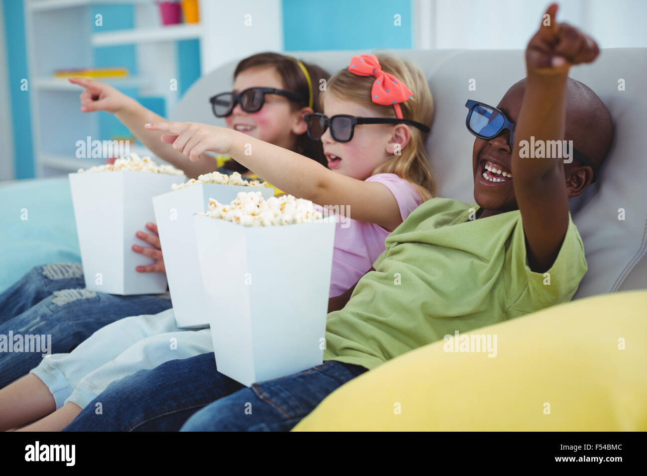 Contenti i bambini seduti insieme la visione di un filmato Foto Stock