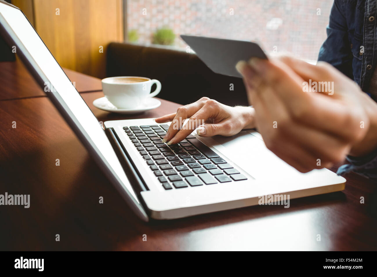 Studente utilizzando laptop in cafe per shop online Foto Stock