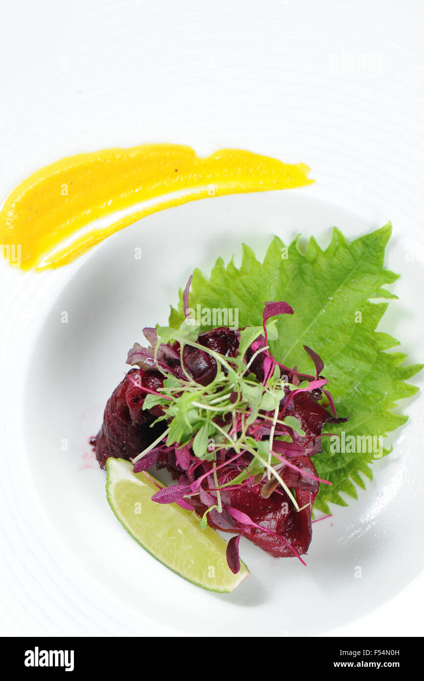 Un rosso barbabietola colorate Salmone Gravalax starter con insalata e calce. Foto Stock