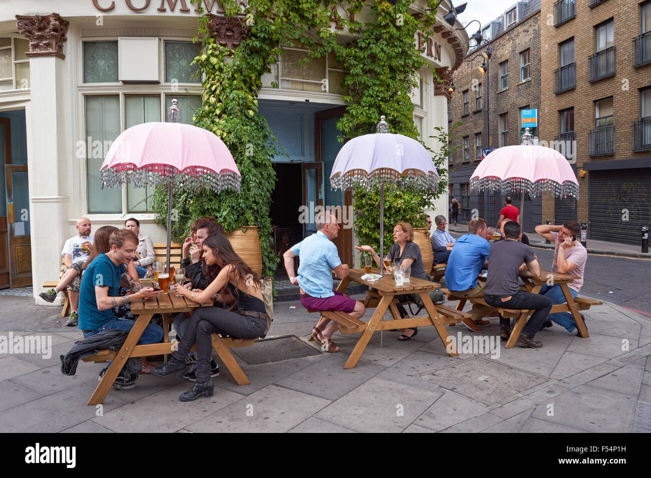 La gente seduta al di fuori della Taverna commerciale pub in Shoreditch, Londra England Regno Unito Regno Unito Foto Stock