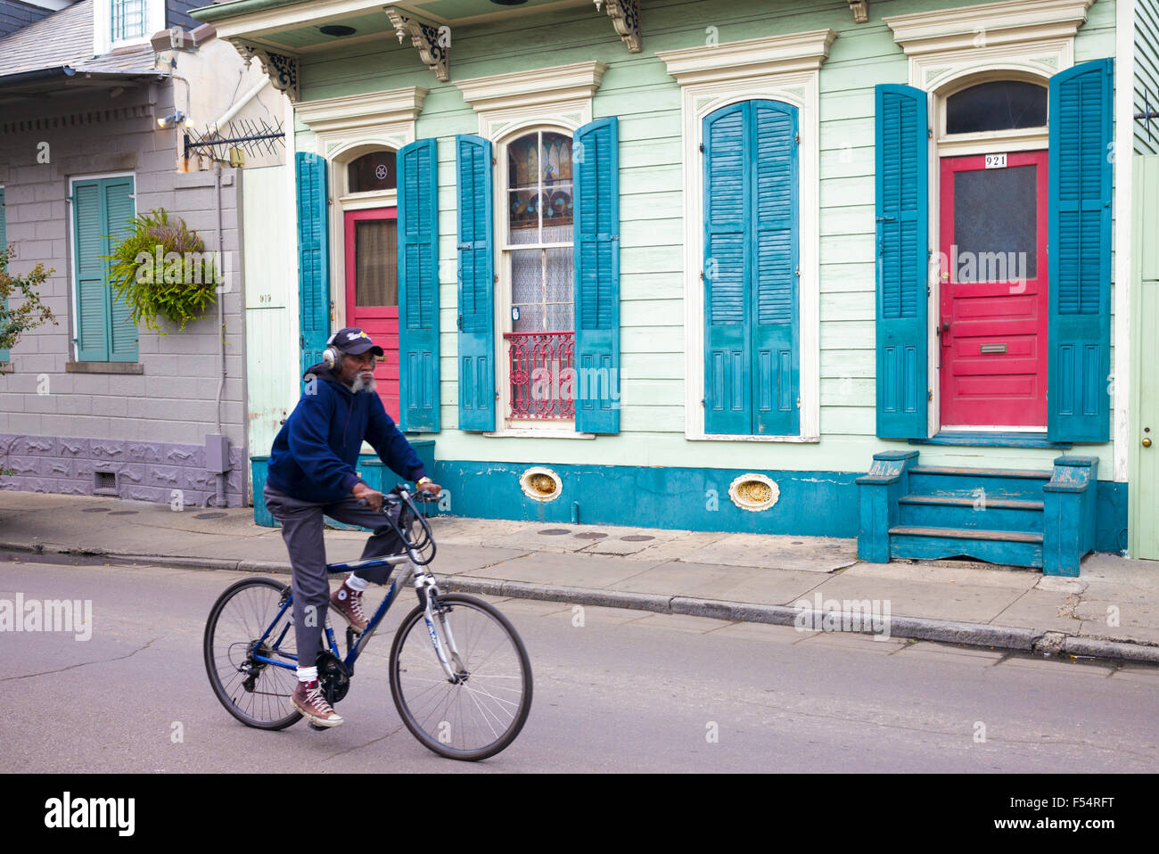 Ciclista passa colore brillante case inferiore lungo Bourbon Street nel Quartiere Francese di New Orleans, in Louisiana, Stati Uniti d'America Foto Stock