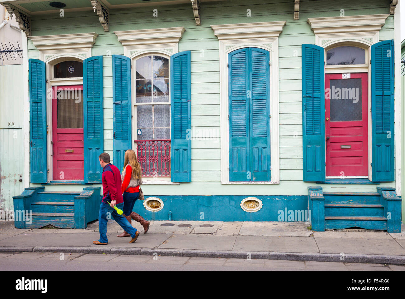 Giovane passando colore brillante case inferiore lungo Bourbon Street nel Quartiere Francese di New Orleans, in Louisiana, Stati Uniti d'America Foto Stock