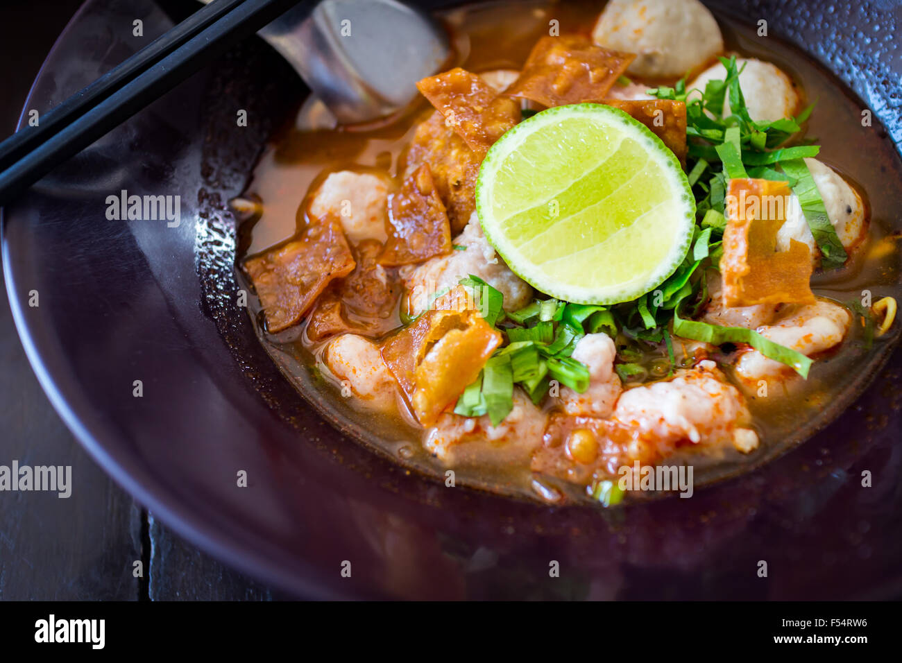 Thai piccante tagliatelle tom yum zuppa con carne di maiale e di limone topping sul cibo di strada in Thailandia Foto Stock