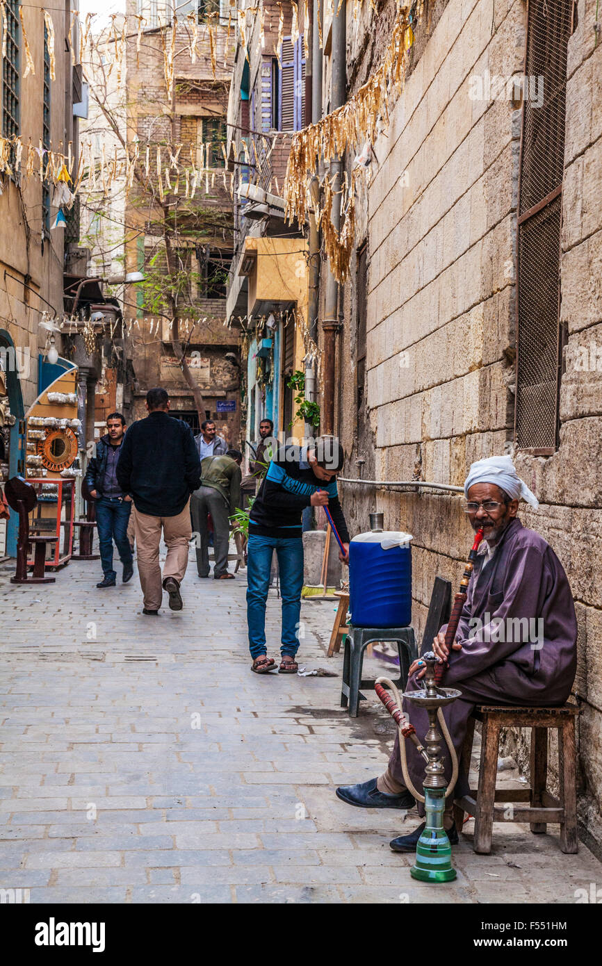 Uomo arabo fuma una tradizionale arabo shisha in Khan el-Khalili souk al Cairo. Foto Stock