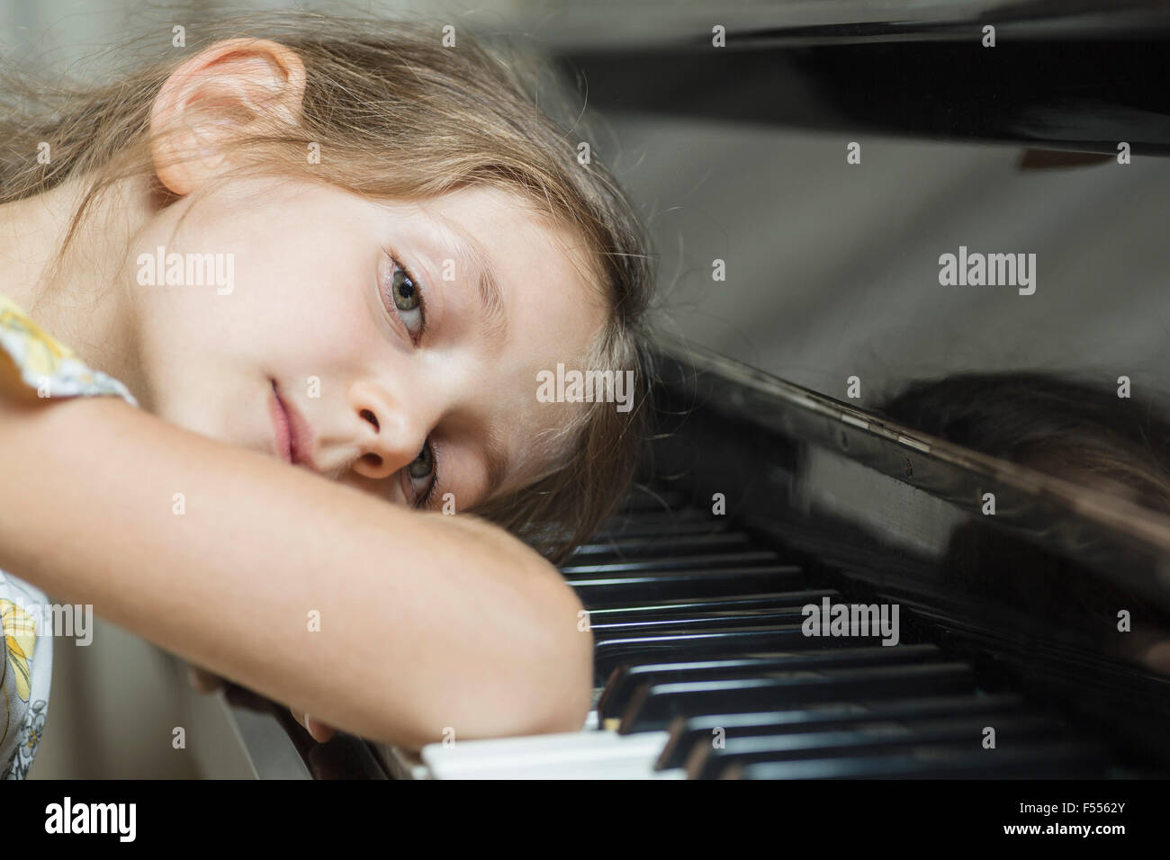 Ritratto di ragazza appoggiata sul pianoforte Foto Stock