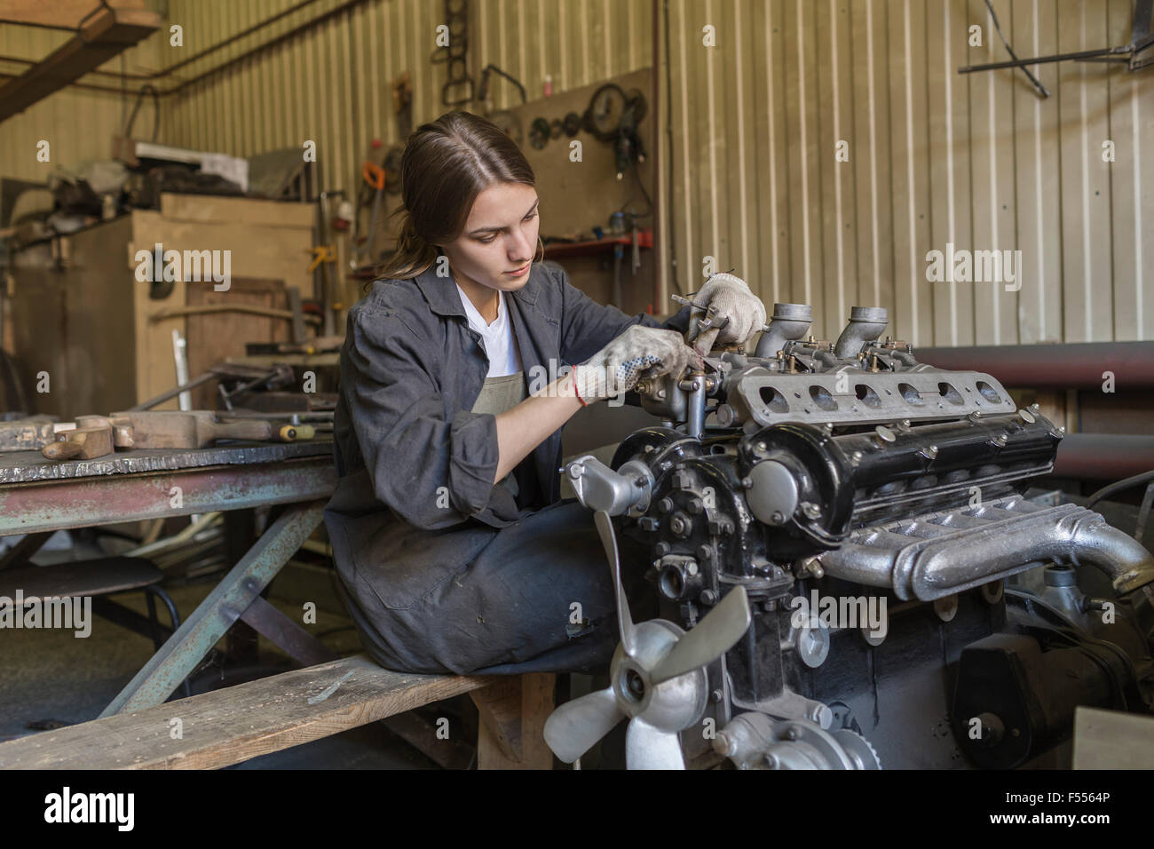 Meccanico femmina riparazione motore auto al garage Foto Stock