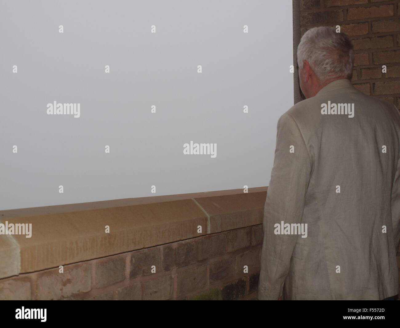 Newcastle Upon Tyne, 28 ottobre 2015, UK Meteo. Un uomo osservando la nebbia meteo sul balcone di un appartamento che si affaccia sul fiume Tyne Tynemouth a. Credito: James Walsh Alamy/Live News Foto Stock