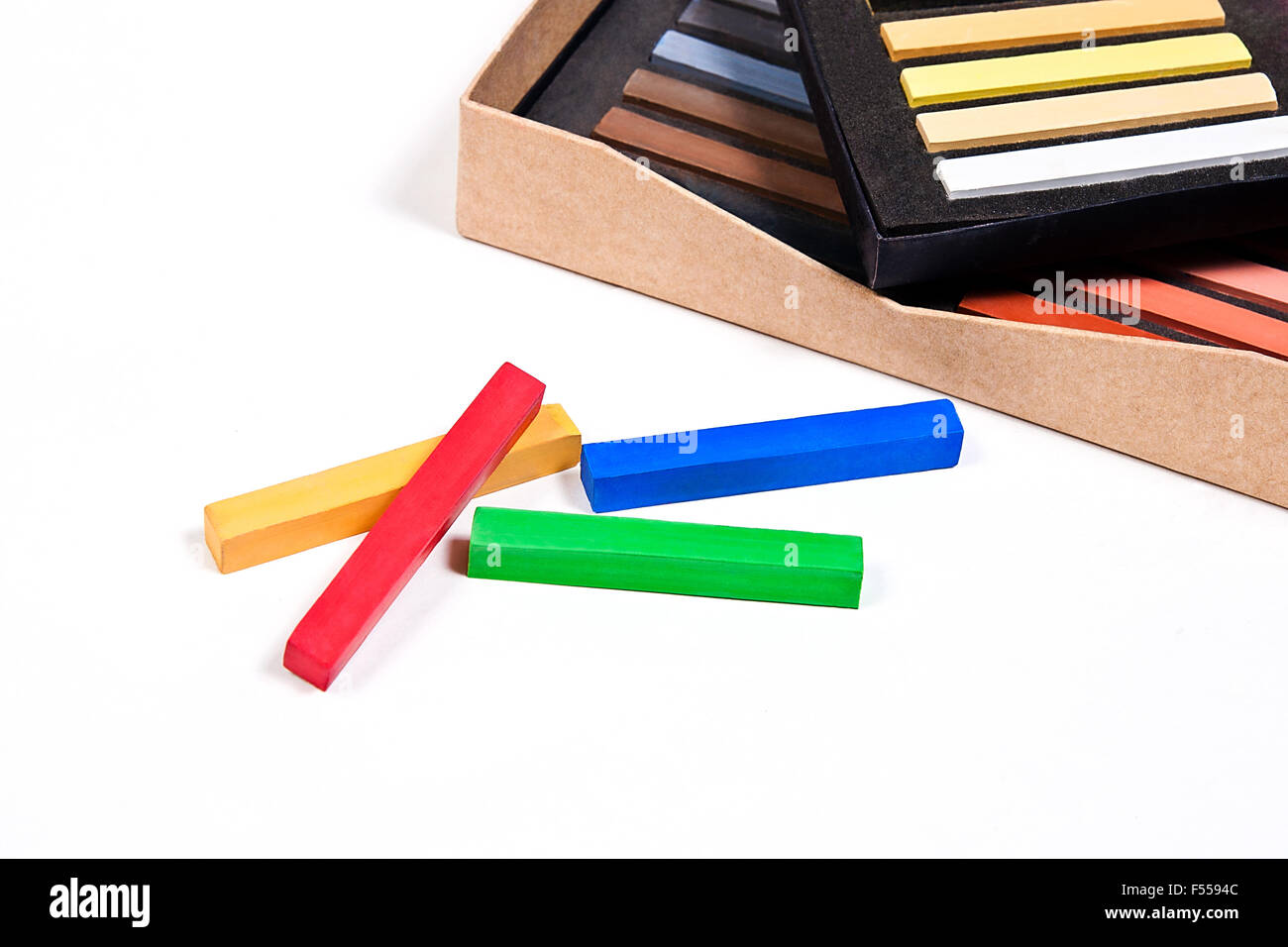 Vista ravvicinata della coloratissima chalk pastelli e scatola su uno sfondo bianco. Foto Stock