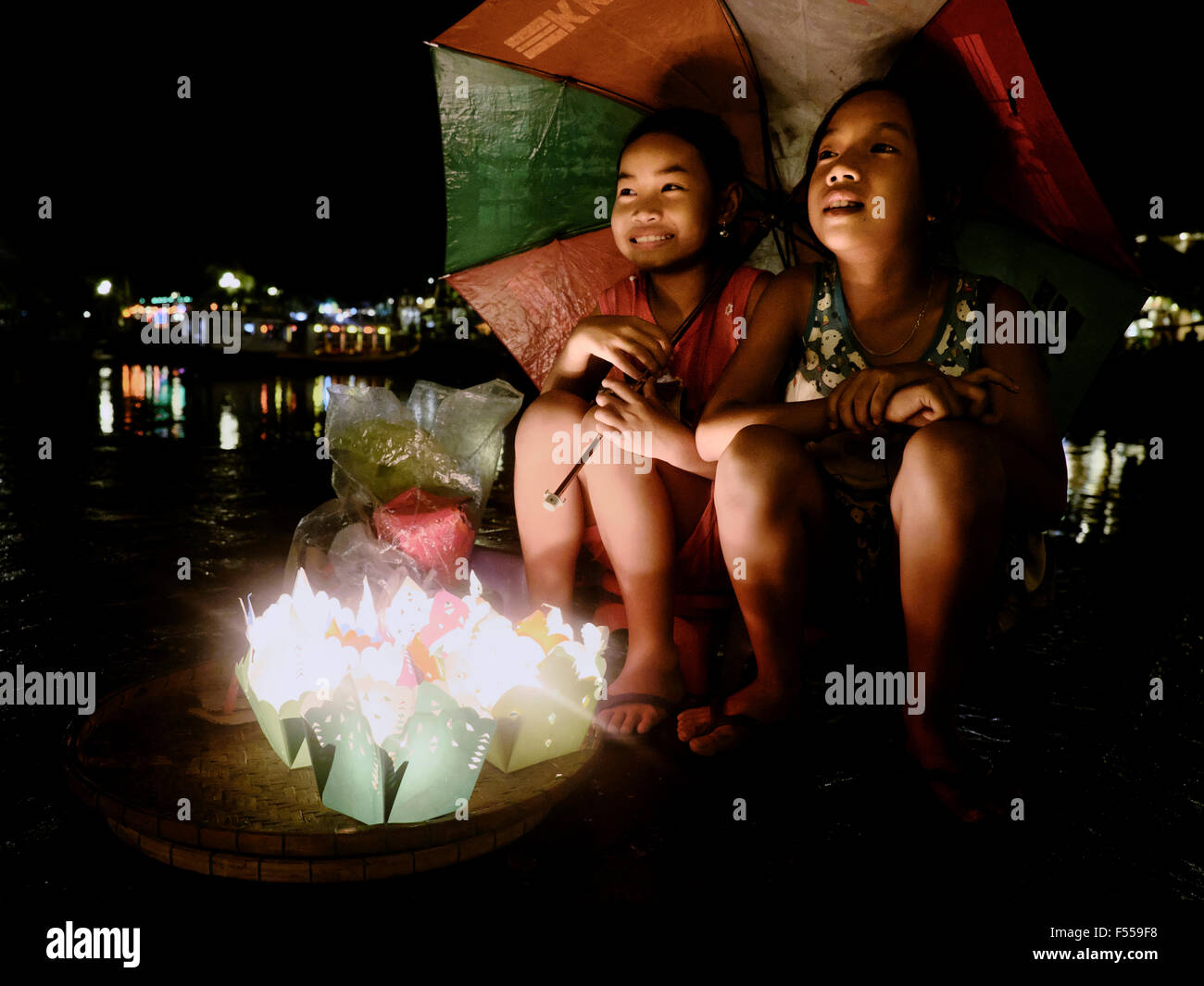 Due ragazze vendere candele progettato per il galleggiante sul fiume in Hoi An, Vietnam centrale. Foto Stock