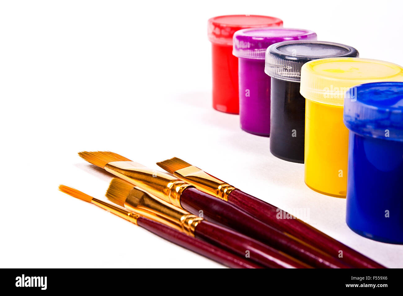 Bottiglie con gouache vernici e diversi tipi di spazzole per quadri artistici. Foto Stock