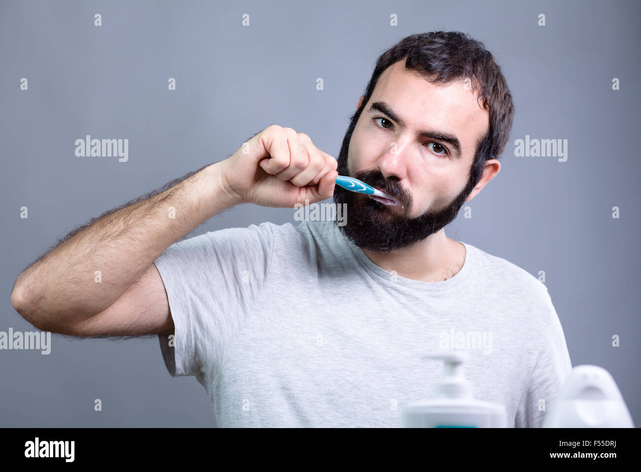 Uomo con barba lavando i denti con uno spazzolino da denti Foto Stock