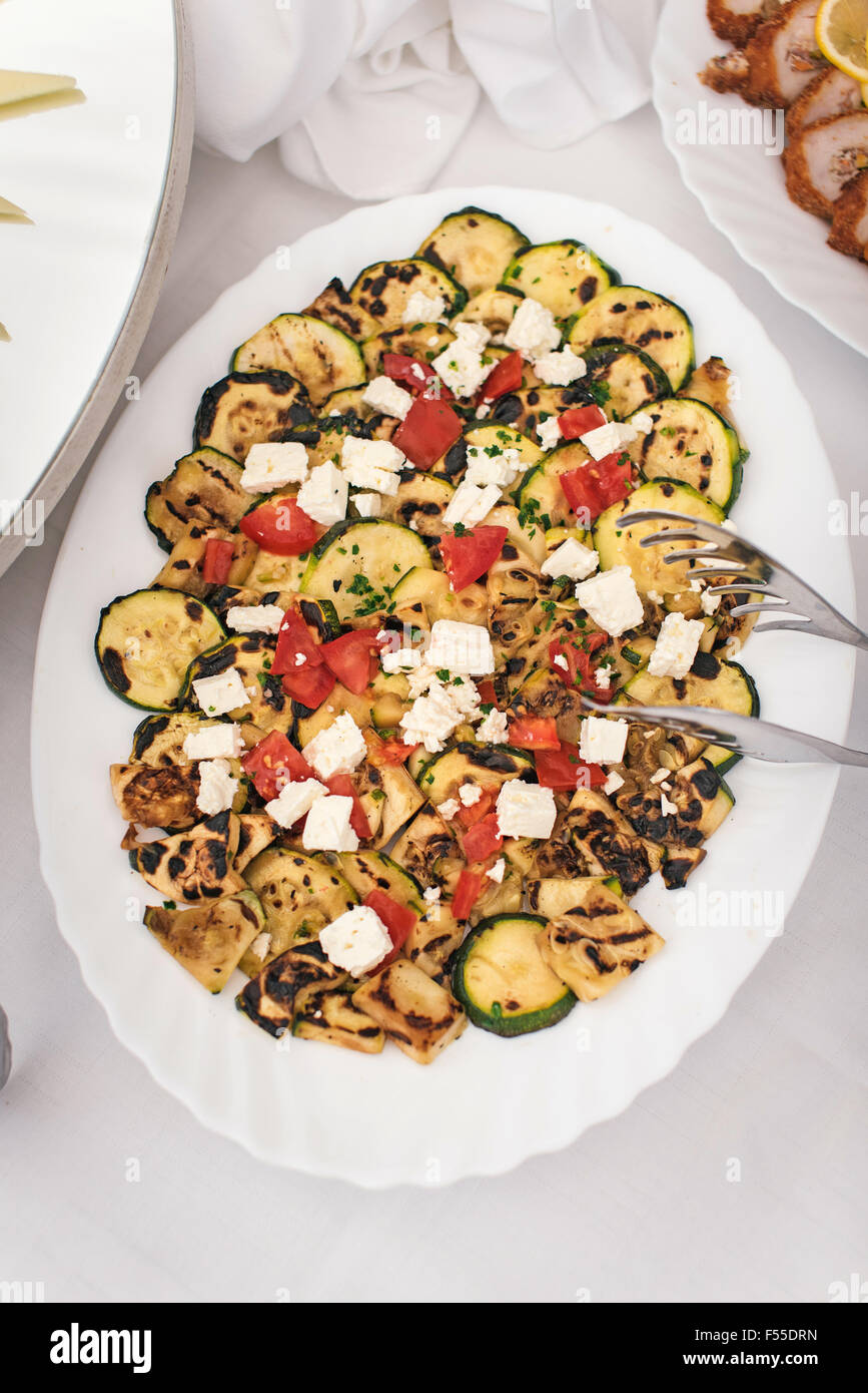 Piastra con zucchine grigliate con formaggio e pomodoro Foto Stock