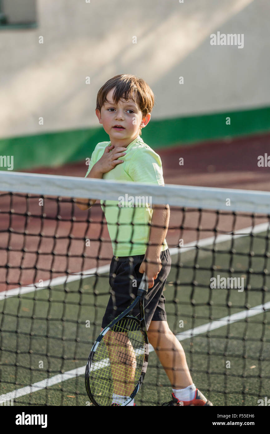 Ragazzo holding racchetta da tennis mentre si sta in piedi sul campo Foto Stock