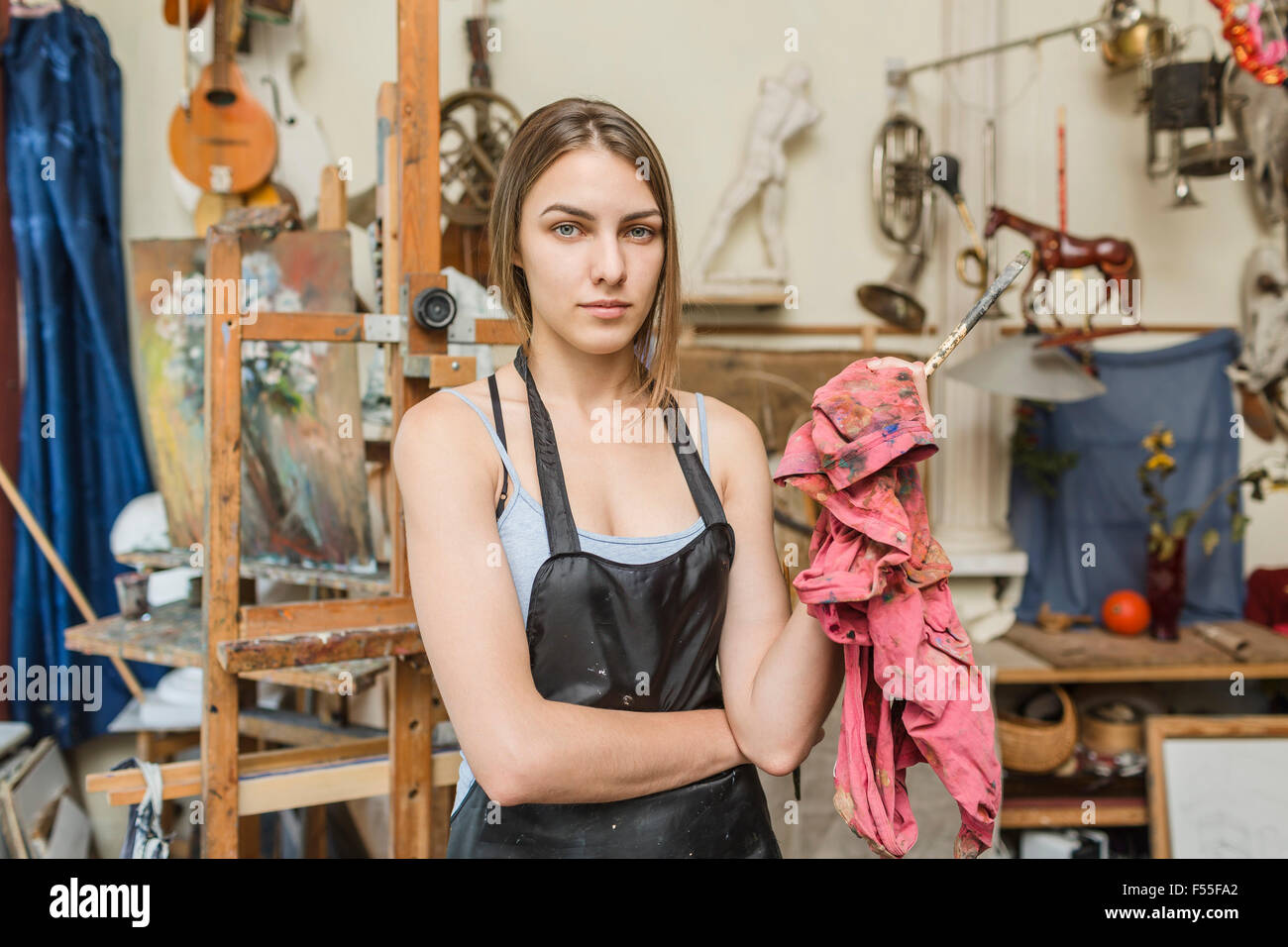 Ritratto di fiducioso pittore femmina in piedi in studio Foto Stock